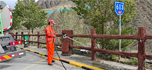 图为：独山子养护所一线职工浇灌独库公路沿线绿色植被 摄影：秦军