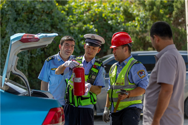 交警在路面检查中逐车查看车载灭火器配备及有效期,确保安全设施齐全有效。 交警在路面检查中逐车查看车载灭火器配备及有效期,确保安全设施齐全有效。