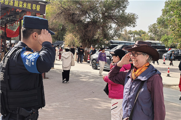 10月16日,北京游客窦奶奶和轮台县公安局民警在塔里木胡杨林公园双向致敬表示感谢。张尧 摄 10月16日,北京游客窦奶奶和轮台县公安局民警在塔里木胡杨林公园双向致敬表示感谢。张尧 摄